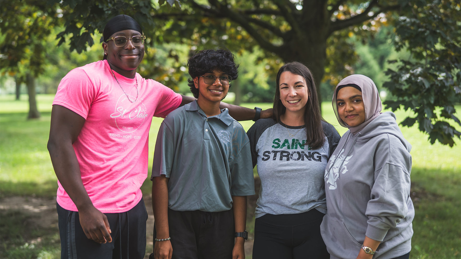 Group of TSI members together in front of a tree